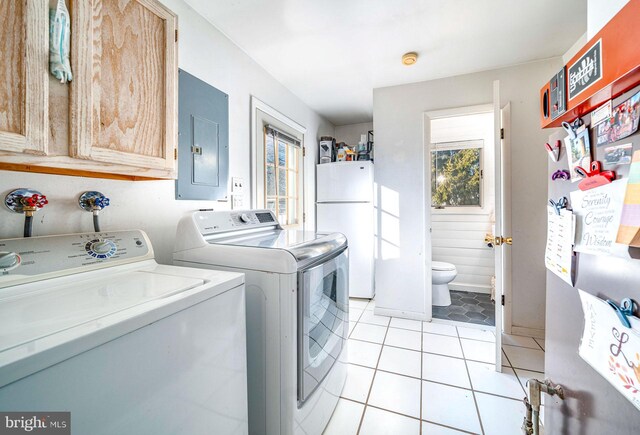 laundry area featuring separate washer and dryer, light tile patterned floors, and electric panel