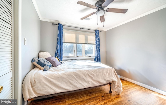 bedroom featuring ornamental molding, hardwood / wood-style floors, and ceiling fan