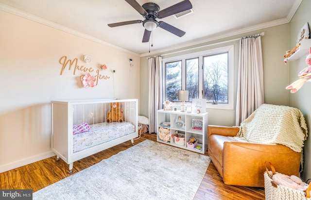 bedroom featuring hardwood / wood-style floors, crown molding, and ceiling fan