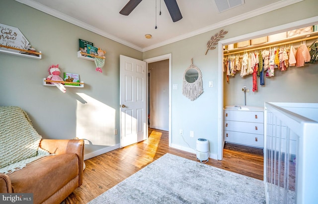 bedroom featuring crown molding, ceiling fan, and light hardwood / wood-style flooring