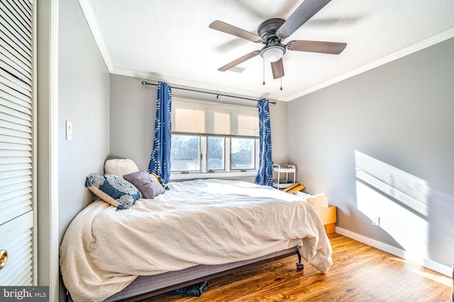 bedroom featuring hardwood / wood-style floors, ornamental molding, a textured ceiling, and ceiling fan