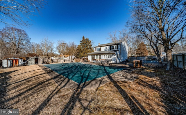 back of house featuring a shed and a covered pool