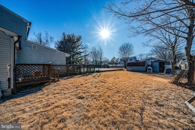 view of yard with a storage shed and a deck