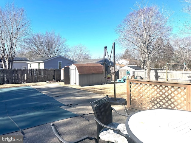 view of patio featuring a storage unit and a playground