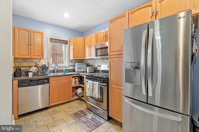 kitchen featuring tasteful backsplash, appliances with stainless steel finishes, light brown cabinetry, and sink