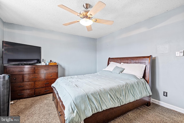 bedroom with ceiling fan, light colored carpet, and a textured ceiling