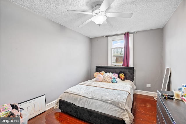 bedroom with ceiling fan, dark hardwood / wood-style floors, and a textured ceiling