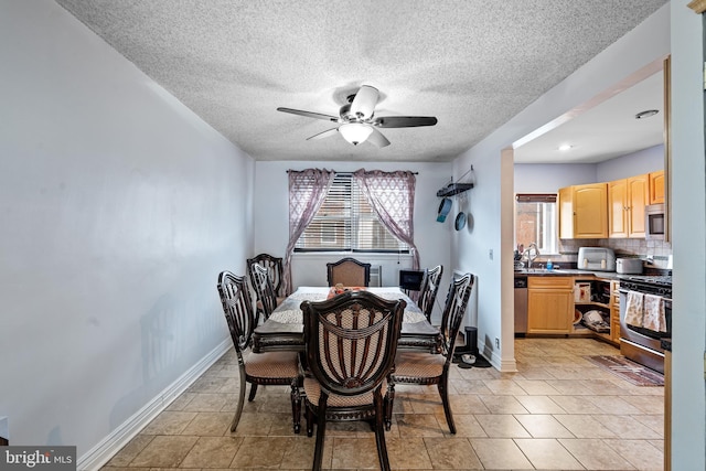 dining area with sink, a textured ceiling, and ceiling fan