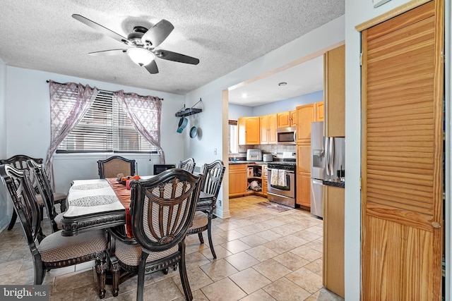 dining space featuring a textured ceiling and ceiling fan