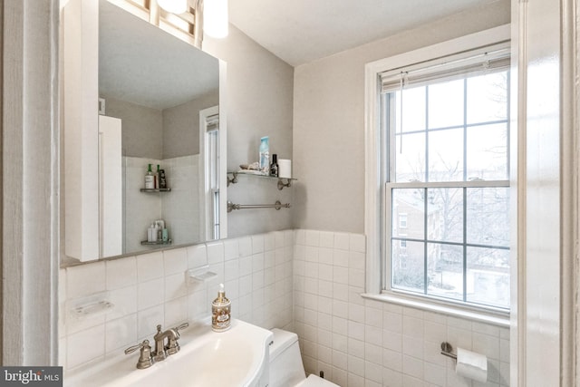 bathroom with toilet and tile walls