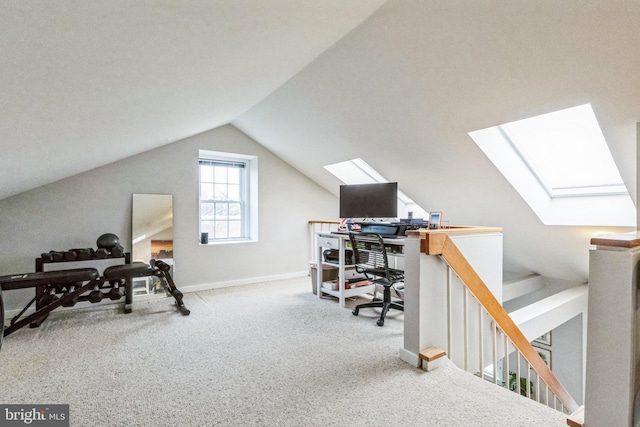 office with vaulted ceiling with skylight and carpet floors