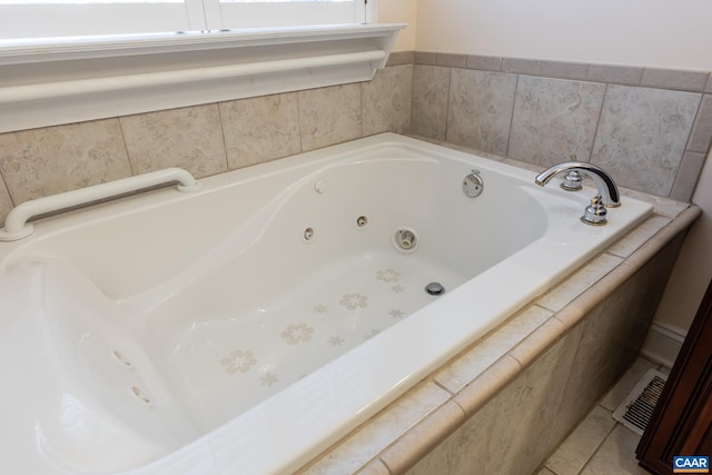 bathroom with tiled tub and tile patterned floors