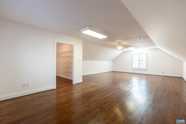 additional living space featuring vaulted ceiling, dark wood-type flooring, and ceiling fan