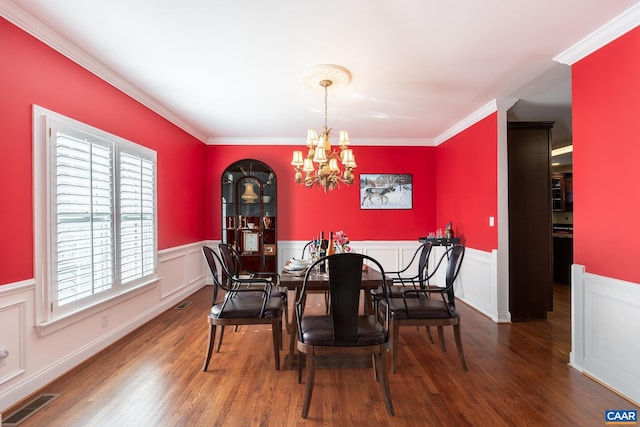 dining space featuring ornamental molding, dark hardwood / wood-style flooring, and a chandelier