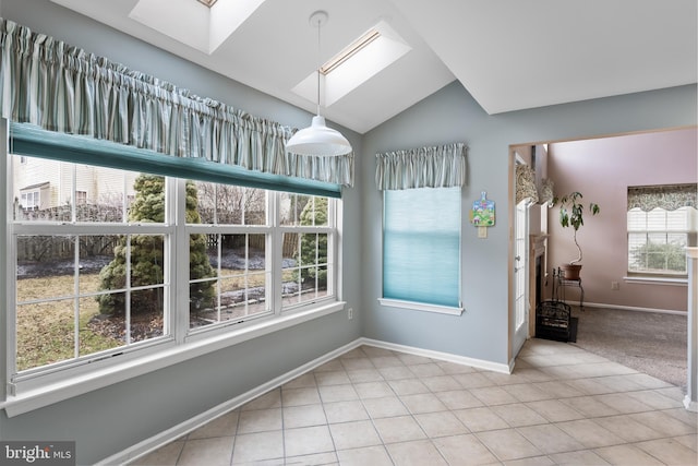 interior space with light tile patterned flooring and lofted ceiling with skylight