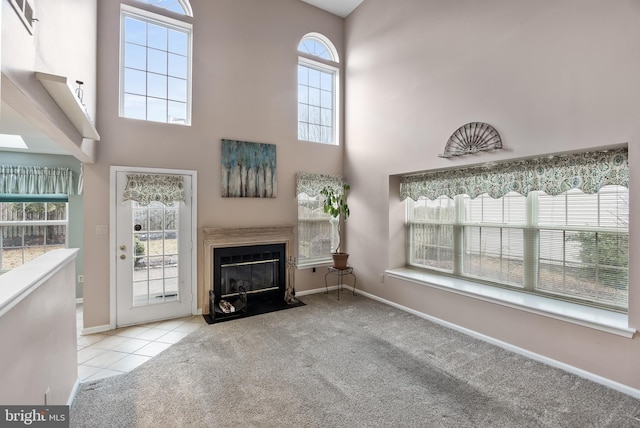 unfurnished living room with a towering ceiling and light colored carpet