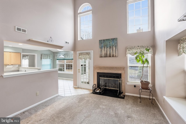 unfurnished living room with light colored carpet and a towering ceiling