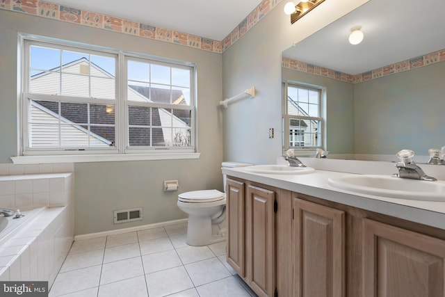 bathroom featuring vanity, toilet, tile patterned flooring, and tiled tub