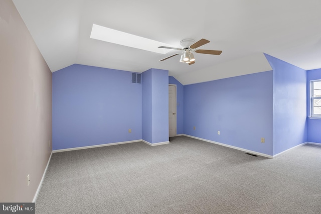 additional living space featuring lofted ceiling with skylight, ceiling fan, and carpet flooring