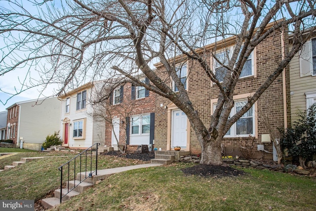 townhome / multi-family property featuring a front lawn