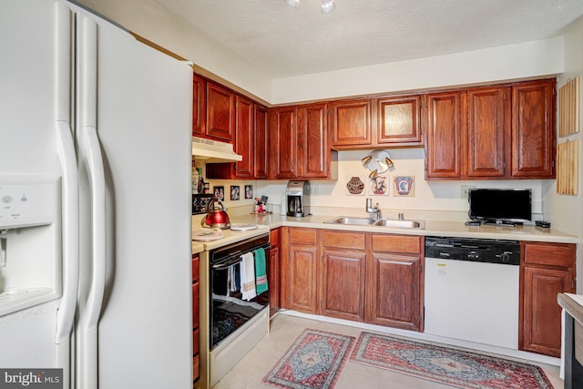 kitchen with sink, light tile patterned floors, a textured ceiling, and white appliances