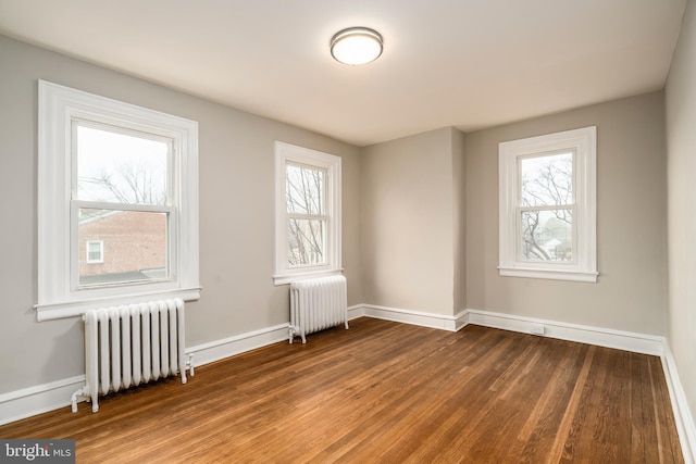 unfurnished room with radiator and hardwood / wood-style flooring