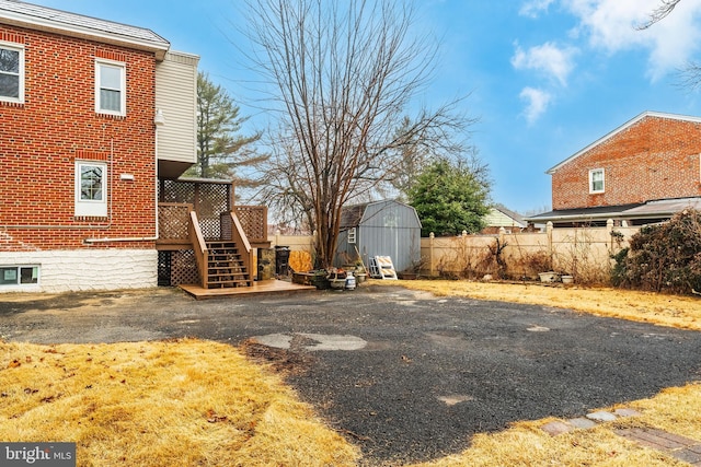 view of yard with a wooden deck and a storage unit