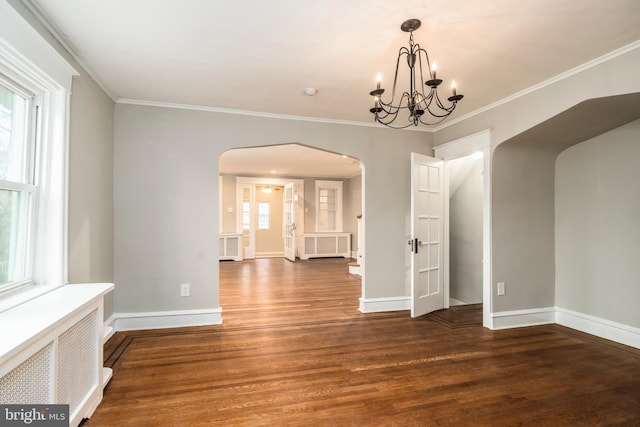 unfurnished dining area with an inviting chandelier, radiator, crown molding, and dark wood-type flooring