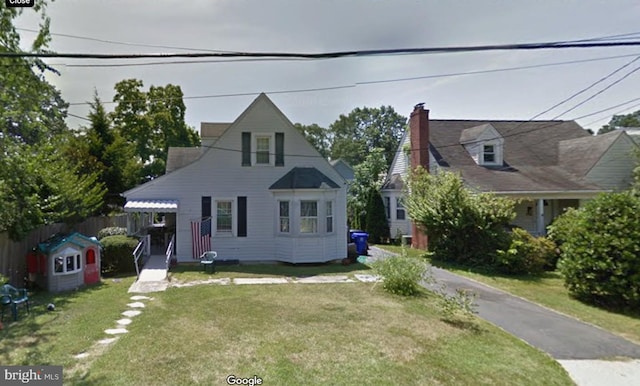 cape cod house featuring a front yard