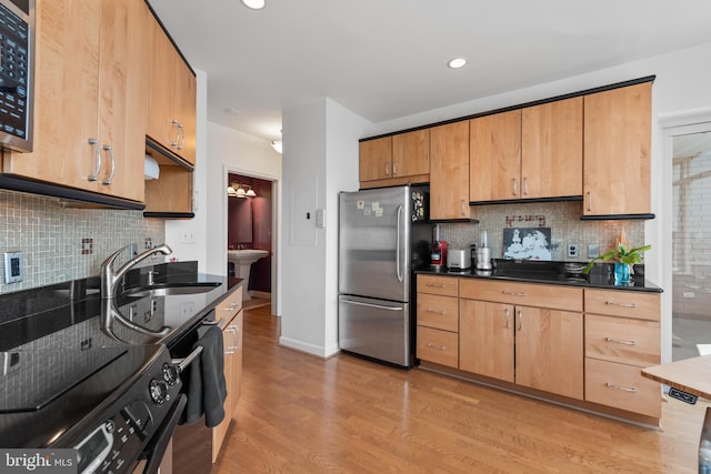 kitchen featuring stainless steel refrigerator, dishwasher, sink, black electric range, and light hardwood / wood-style flooring