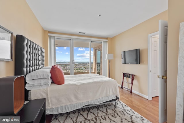 bedroom with hardwood / wood-style floors and access to exterior