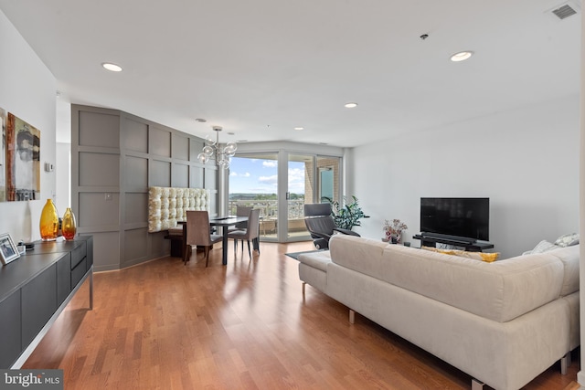 living room featuring a chandelier and light hardwood / wood-style floors