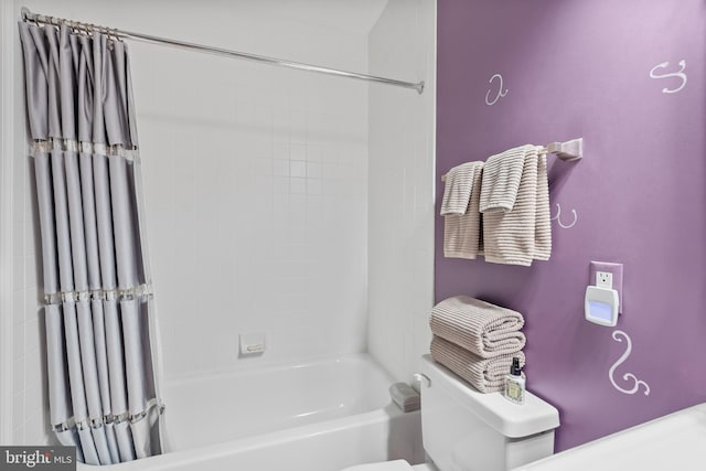 bathroom featuring shower / bathtub combination with curtain and toilet