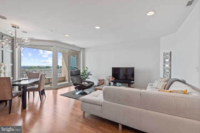 living room featuring an inviting chandelier and light hardwood / wood-style flooring