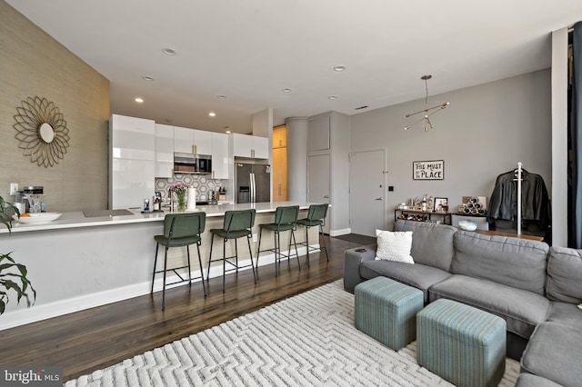 living room with baseboards, dark wood-style flooring, and recessed lighting