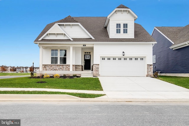 view of front facade featuring a garage, a porch, and a front yard