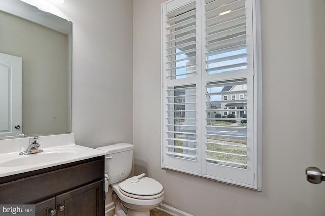 bathroom with vanity, toilet, and a healthy amount of sunlight