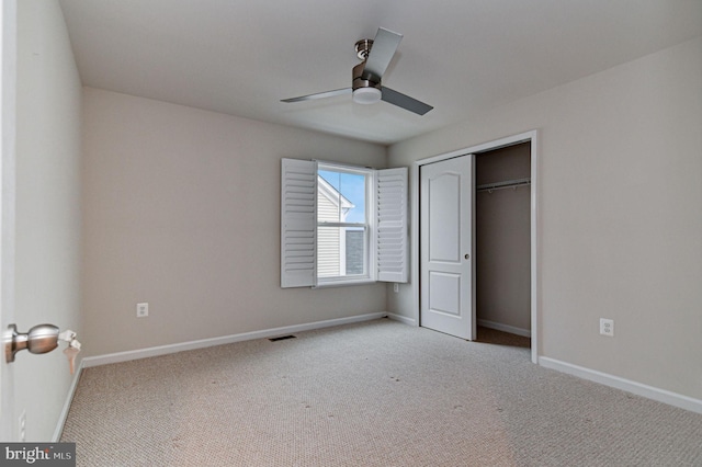 unfurnished bedroom with light colored carpet, ceiling fan, and a closet