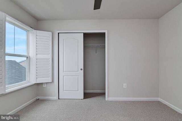 unfurnished bedroom with light colored carpet, ceiling fan, and a closet