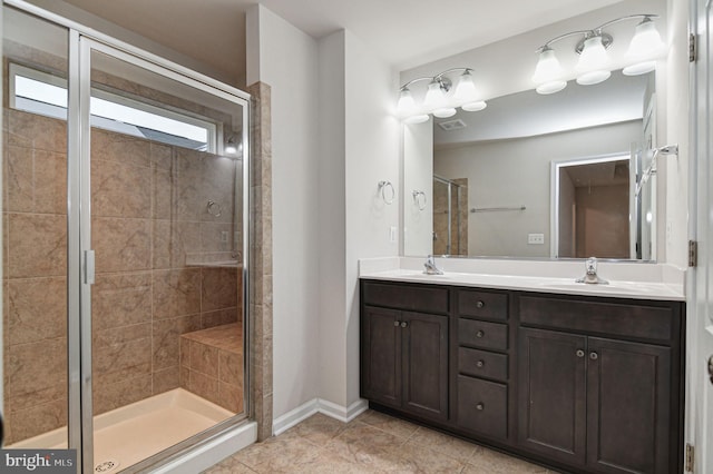 bathroom with a shower with door, vanity, and tile patterned floors