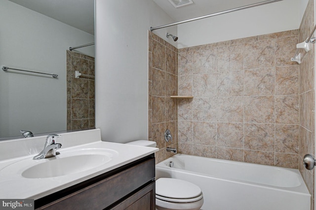 full bathroom featuring vanity, tiled shower / bath combo, and toilet