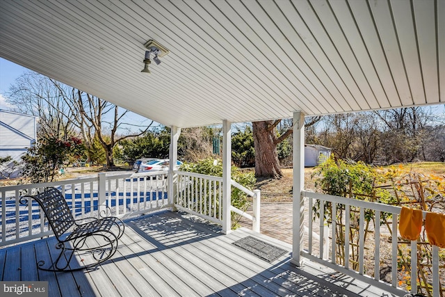 wooden deck featuring an outdoor structure and a storage shed