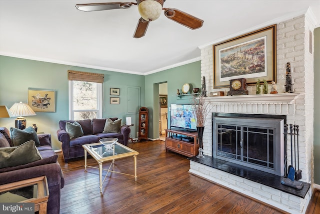 living room with a fireplace, crown molding, a ceiling fan, wood finished floors, and baseboards