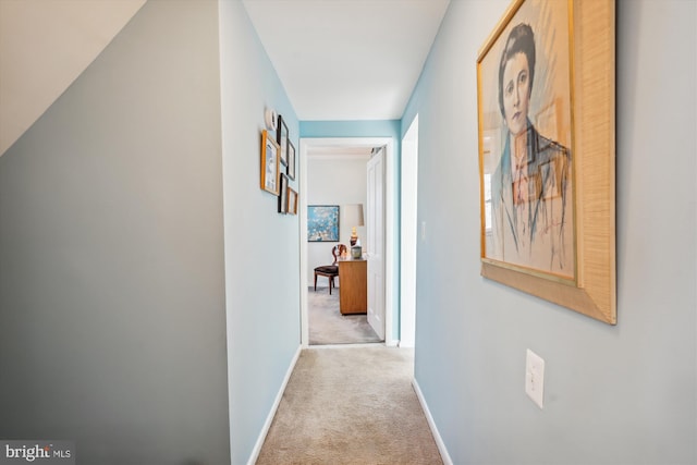 corridor featuring baseboards and carpet flooring