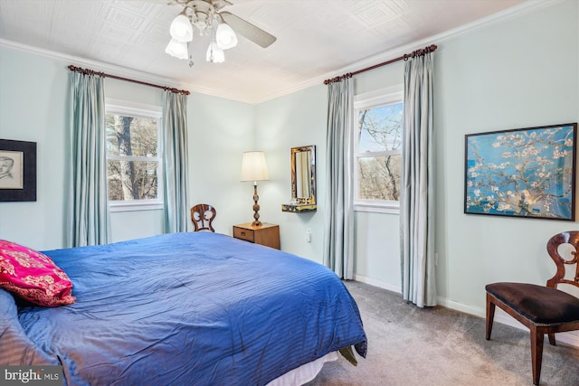 carpeted bedroom with ceiling fan, ornamental molding, and baseboards