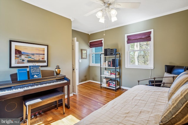 bedroom featuring baseboards, ornamental molding, ceiling fan, and wood finished floors