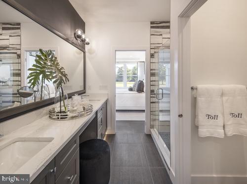 bathroom featuring tile patterned floors, vanity, and a shower with door