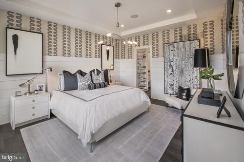 bedroom featuring dark hardwood / wood-style floors, an inviting chandelier, and a tray ceiling