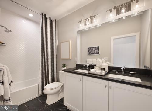 full bathroom with tile patterned flooring, vanity, toilet, and shower / bath combo with shower curtain