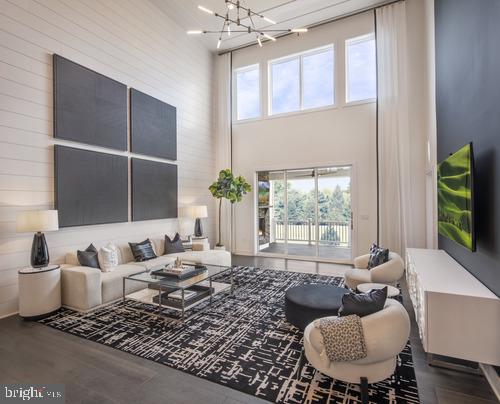 living room with hardwood / wood-style flooring, a chandelier, and a high ceiling